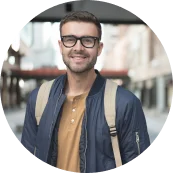 Portret van Lars De Groot met bril en casual kleding, glimlachend in een straatsetting.